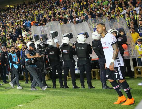 Fenerbahce v Besiktas: Ziraat Turkish Cup ISTANBUL, TURKEY - APRIL 19: Police officers hold shields as Quaresma (7) of Besiktas takes corner after fans throw objects to pitch during Ziraat Turkish Cup Semi Final second leg soccer match between Fenerbahce and Besiktas at the Ulker Stadium in Istanbul, Turkey on April 19, 2018. The match was cancelled after the latest incidents. Istanbul Turkey. Editorial use only. Please get in touch for any other usage. Copyright: x2025xAnadoluxMetinxPalax