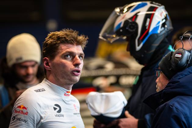 Max Verstappen stands in the paddock and talks to team members Racing helmets and team equipment can be seen in the background, documenting the intensive preparation for the 24-hour race at the Nürburgring Max Verstappen in the paddock at the 24h Nürburgring 2026 Copyright: xMichaelxGelhardtx