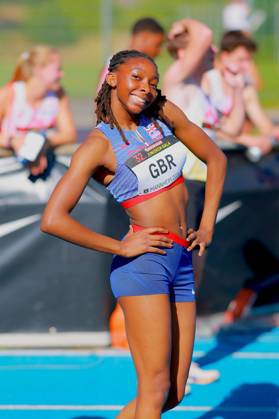 An athlete from Great Britain poses smiling on the tartan track of the Michael Hoffmann Stadium in Mannheim Her bib number reads GBR and the words 32 Junior Gala Mannheim 2024 Athlete from Great Britain at the 32 Junior Gala in Mannheim Copyright: xspeedshotx