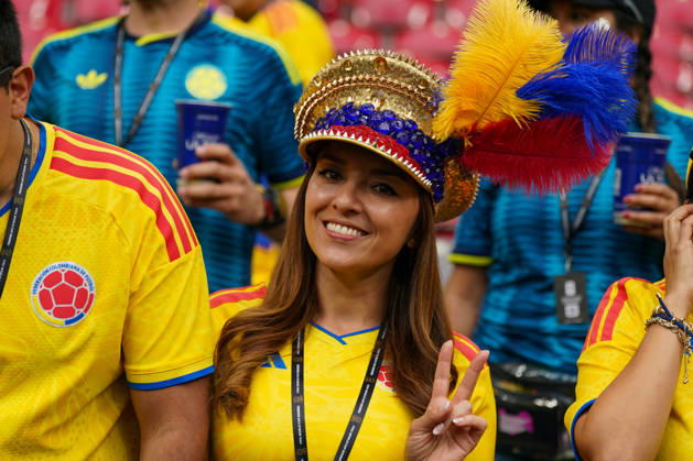 Canada Soccer FIFA World Cup 2026, Round of 16: Switzerland vs. Colombia at BC Place, Vancouver; portrait of Colombian soccer fans; female fan; Colombia; national team; 2026 FIFA World Cup, 2026 World Cup, fan portrait, female spectator, fan culture, yellow national jersey, feathered hat in the national colors of yellow, blue, and red, victory sign, smile, stands, stadium, soccer, support, atmosphere, supporters, Team Colombia, accessory, accreditation wristband, sporting event Copyright: xJOERANxSTEINSIEKx