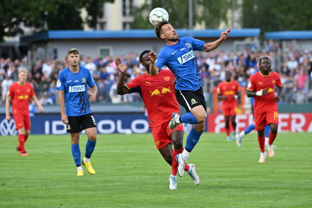 August 22, 2026, xjhx, Soccer, DFB Cup First Round, Eintracht Trier vs. RB Leipzig, Ridle Baku, RB Leipzig, Jonas Singer, SV Eintracht Trier 05, tackle, action, battle for the ball, Trier