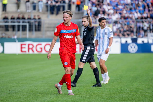 Jonas Therkelsen of Holstein Kiel (No. 10) receives a yellow card from referee Felix Weller; GER, TSV 1860 Munich vs. Holstein Kiel, Soccer, DFB Cup, 1st Round, 2026–2027 Season, August 22, 2026 DFL DFB regulations prohibit any use of photographs as image sequences and or quasi-video. Photo: HMB Media, Heike Feiner Copyright: HMBxMedia HeikexFeiner