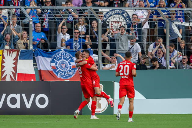 Guillermo Balzi, Holstein Kiel, 08, celebrates with Phil Harres, Holstein Kiel, 19, after his goal to make it 0-1 GER, TSV 1860 Munich vs. Holstein Kiel, Soccer, DFB Cup, Round 1, 2026–2027 season, August 22, 2026 DFL and DFB regulations prohibit any use of photographs as image sequences and or quasi-video. Photo: HMB Media, Heike Feiner Copyright: HMBxMedia HeikexFeiner