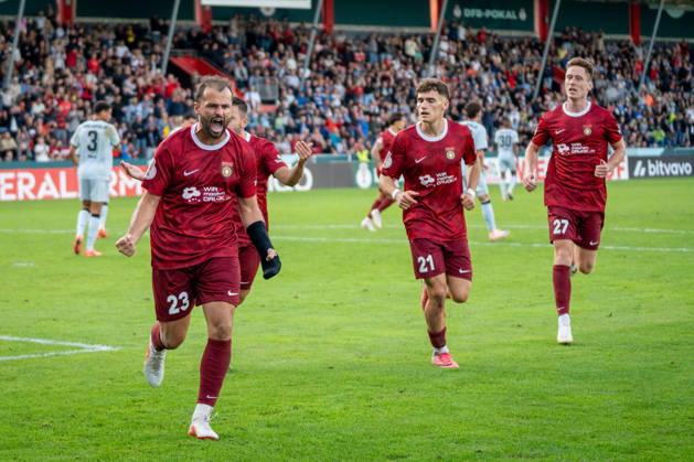 Fabian Eisele of SG Sonnenhof Großaspach, 23, celebrates after scoring a penalty kick to tie the game at 2–2 with Luca Molinari of SG Sonnenhof Großaspach, 21, Loris Maier (SG Sonnenhof Großaspach, 27), and Marius Kunde (SG Sonnenhof Großaspach, 16), SG Sonnenhof Großaspach vs. Arminia Bielefeld, soccer, DFB Cup, 1st round, August 22, 2026, DFB regulations prohibit any use of photographs as image sequences and or quasi-video. Aspach, Baden-Württemberg, Germany Copyright: xkolbert-press PhilipxZieglerx