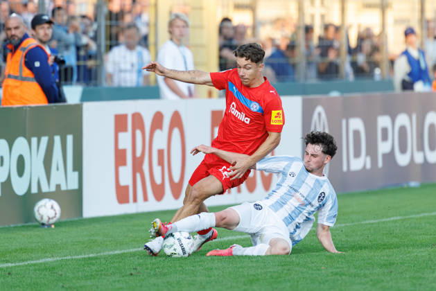 Moritz Reimers, 22, Holstein Kiel, and Lance Fiedler, 47, TSV 1860 Munich, during the match between TSV 1860 Munich and Holstein Kiel, soccer, men s, DFB Cup, 2026–2027, Round 1 on August 22, 2026, in Munich, Städtisches Stadion an der Grünwalder Straße, Bavaria, Germany