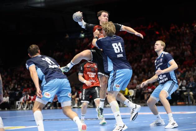 An MTV Braunschweig player jumps to shoot and is blocked by Martin Hovde (81), HSV Hamburg. Einar Olafsson (23), HSV Hamburg, watches the action from the background at the Volkswagen Halle in Braunschweig. An MTV Braunschweig player shoots against Martin Hovde (81), HSV Hamburg. Copyright: xspeedshotx