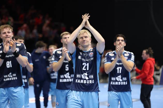 Frederik Bo Andersen, 21, of HSV Hamburg, applauds with his hands raised toward the fans, flanked by Martin Hovde 81 of HSV Hamburg and Kaj Geenen 17 of HSV Hamburg. The entire team celebrates together at the Volkswagen Halle in Braunschweig. Frederik Bo Andersen 21 of HSV Hamburg celebrates with the team. Copyright: xspeedshotx