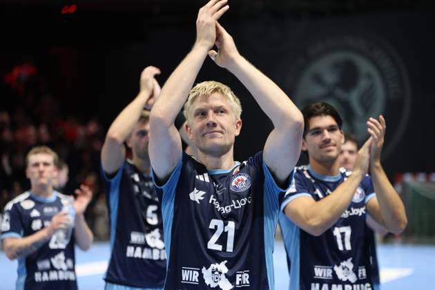 Frederik Bo Andersen, No. 21 of HSV Hamburg, claps his hands with his arms raised and celebrates with his teammates, including Kaj Geenen, 17, of HSV Hamburg, celebrating the victory at the Volkswagen Halle in Braunschweig. The entire HSV Hamburg team applauds together toward the fans. Frederik Bo Andersen, 21, of HSV Hamburg, and Kaj Geenen, 17, of HSV Hamburg, celebrate. Copyright: xspeedshotx