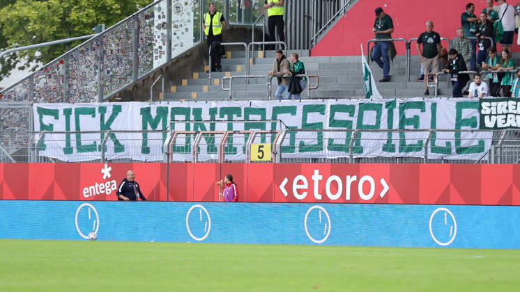 SV Werder Bremen fans display a banner in the fan section with the words Fuck Monday Games, protesting Monday games in the Women’s Bundesliga; fans, ultras, crowd, spectators, mood, atmosphere, stadium, DFB GUIDELINES PROHIBIT ANY USE OF PHOTOS AS SEQUENCE IMAGES AND OR VIDEO-LIKE PHOTO SERIES DFB REGULATIONS PROHIBIT ANY USE OF PHOTOGRAPHS AS IMAGE SEQU, August 24, 2026, Mainz, Germany, soccer, Google Pixel Women’s Bundesliga, 1. FSV Mainz 05 vs. SV Werder Bremen xobx