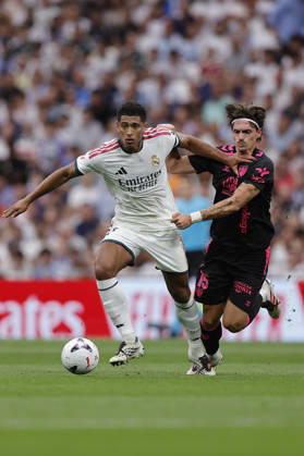 Jude Bellingham of Real Madrid CF and Angel Recio of Málaga CF battle for the ball during the LaLiga EA Sports match between Real Madrid CF and Málaga CF at Estadio Santiago Bernabéu on August 30, 2026, in Madrid, Spain. Photo by Manu Reino, DeFodi Images