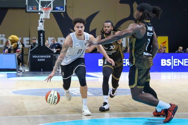 September 4, 2026, xgox, Basketball Exhibition Game: Basketball Loewen Braunschweig vs. Bamberg Baskets, emspor, from left: Joshua Obiesie (Bamberg), 77; Chip Flanigan (Braunschweig), 30; head-to-head battle, duel, fight, tackle (Braunschweig)