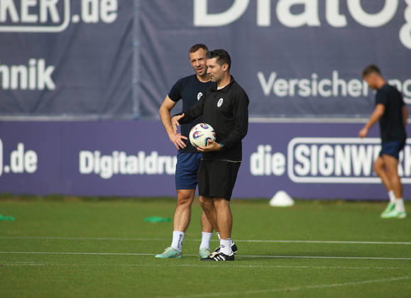 Soccer, Men s, Bavarian Regional League, 2026–2027 Season, TSV 1860 Munich, Training, Grünwalder Strasse 114 Felix Weber (TSV 1860 Munich, left) and Alper Kayabunar (TSV 1860 Munich coach, right) standing together on the field, engaged in conversation