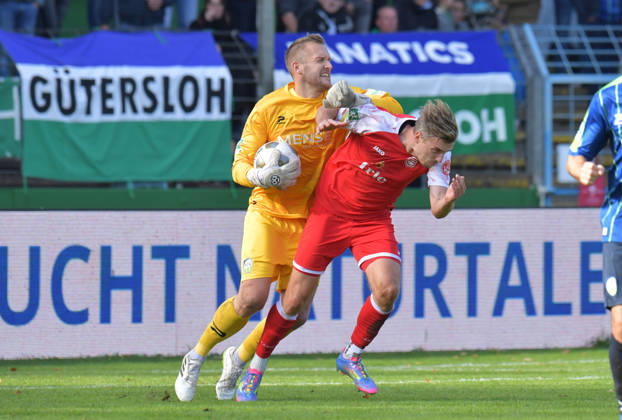 October 10, 2026, Germany, Soccer, Regionalliga West, 2026–2027 Season, Matchday 12, Ohlendorf Stadium in Heidewald, Gütersloh FC vs. SF Siegen 0–5. Goalkeeper Jarno Peters of FC Gütersloh (left) against Elias Paul Huth of SF Siegen—action, duel, tackle