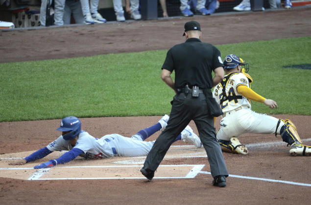 Los Angeles Dodgers Mookie Betts (50) scores past Milwaukee Brewers catcher William Contreras (24) on a sacrifice fly by Teoscar Hernandez in the first inning in game two of the MLB, Baseball Herren, USA National League Championship Series at American Family Field in Milwaukee, Wisconsin, on Monday, October 12, 2026.  MIL20261012703 TANNENxMAURY