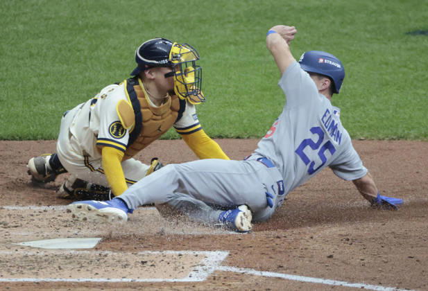 Los Angeles Dodgers Tommy Edman (25) slides safely past Milwaukee Brewers catcher William Contreras (24) to score on a sacrifice fly by Dodger Freddie Freeman in the fifth inning in game two of the MLB, Baseball Herren, USA National League Championship Series at American Family Field in Milwaukee, Wisconsin, on Monday, October 12, 2026.  MIL20261012723 TANNENxMAURY