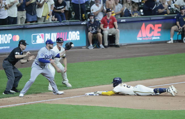 Milwaukee Brewers William Contreras (24) slides safely into third as Los Angeles Dodgers third baseman Max Muncy (13) takes a throw in the eighth inning in game two of the MLB, Baseball Herren, USA National League Championship Series at American Family Field in Milwaukee, Wisconsin, on Monday, October 12, 2026.  MIL20261012745 TANNENxMAURY