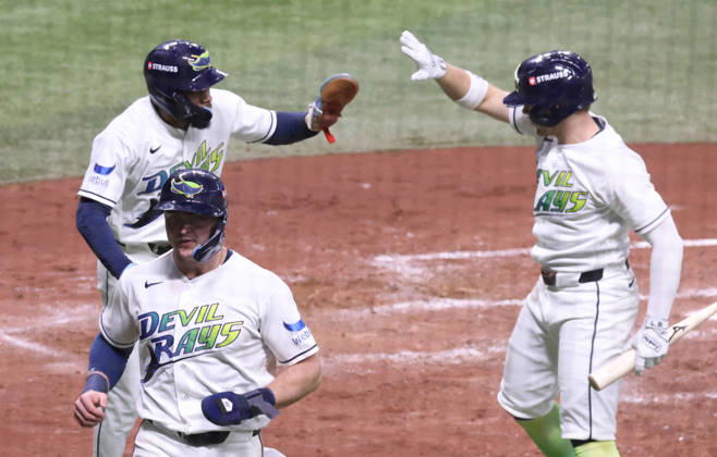 Tampa Bay Rays Taylor Walls (R) congratulates Chandler Simpson (14) after Simpson scored on a single by Liam Hicks against the Cleveland Guardians in the fourth inning in game two of the MLB, Baseball Herren, USA American League Championship Series playoffs at Tropicana Field in St Petersburg, Florida, on Tuesday, October 13, 2026.  TPB20261013718 GARYxBOGDON