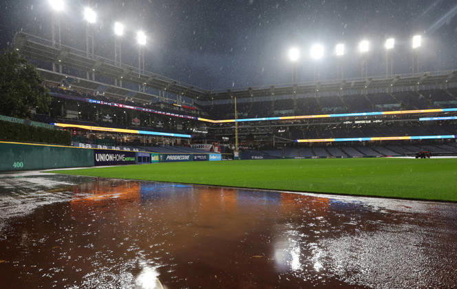 Water pools on the outfield as a heavy rain falls before the start of game four of the MLB, Baseball Herren, USA American League Championship Series between the Tampa Bay Rays and the Cleveland Guardians at Progressive Field in Cleveland, Ohio, on Friday, October 16, 2026. The 8pm ET start of the game has been delayed due to the weather.  CLE20261016706 AARONxJOSEFCZYK