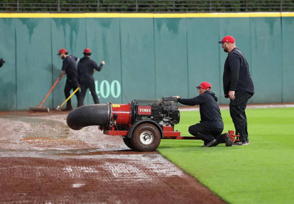 The groundskeeping crew uses a large fan to help dry off the warning track in the outfield after heavy rains fell before the start of game four of the MLB, Baseball Herren, USA American League Championship Series between the Tampa Bay Rays and the Cleveland Guardians at Progressive Field in Cleveland, Ohio, on Friday, October 16, 2026. The 8pm ET start of the game has been delayed due to the weather.  CLE20261016708 AARONxJOSEFCZYK