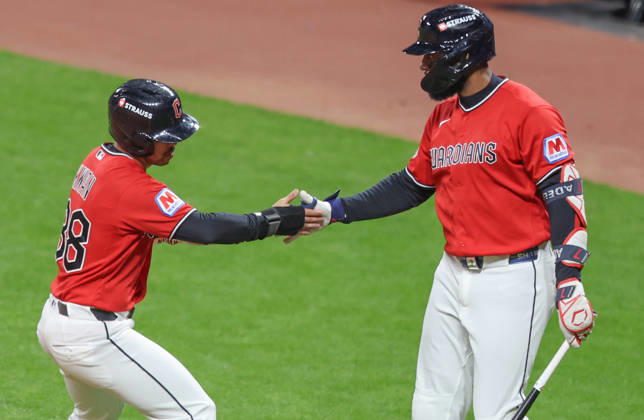 Cleveland Guardian Steven Kwan (38) is congratulated by Jo Adell after scoring on a hit by Chase DeLauter in the first inning against the Tampa Bay Rays during game four of the MLB, Baseball Herren, USA American League Championship Series at Progressive Field in Cleveland, Ohio, on Saturday, October 16, 2026.  CLE20261017706 AARONxJOSEFCZYK