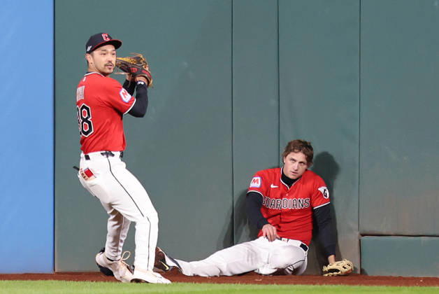 Cleveland Guardians center fielder Petey Halpin (R) sits on the ground after going up against the wall to catch a long fly ball from Tampa Bay Rays Junior Caminero as left fielder Steven Kwan (38) assists in the fourth inning during game four of the MLB, Baseball Herren, USA American League Championship Series at Progressive Field in Cleveland, Ohio, on Saturday, October 17, 2026.  CLE20261017715 AARONxJOSEFCZYK