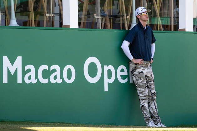 October 18, 2026, Macau, Macao Sar, China: Charles PORTER from the USA takes the tied lead on -14 Par with a stunning -9 Par final round. PORTER and his caddy hide from the heat in the shade of the hospitality stand on the 18th green. Macau Open Golf 2026 Final Round. Macau Open Golf 2026 Final Round  - ZUMAr144 20261018_zap_r144_048 Copyright: xJaynexRussellx