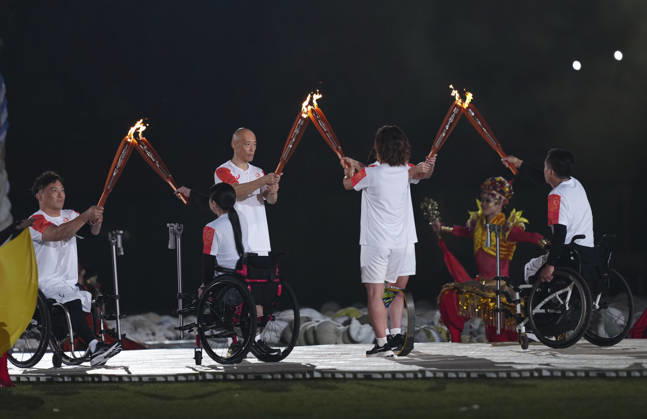 (261018) -- NAGOYA, Oct. 18, 2026 -- Torch bearers hand over the flame during the opening ceremony of the Aichi-Nagoya Asian Para Games in Nagoya, Japan, Oct. 18, 2026. ) (SP)JAPAN-NAGOYA-ASIAN PARA GAMES-OPENING CEREMONY JiaxHaocheng 