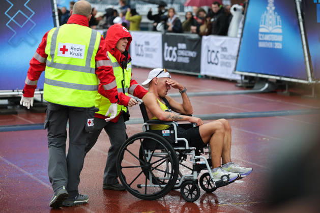 RECORD DATE NOT STATED 18th October 2026; Amsterdam, Netherlands; TCS Amsterdam Marathon; A runner is wheeled off the track in the Olympic Stadium by Red Cross first aid staff AnthonyxBenoit