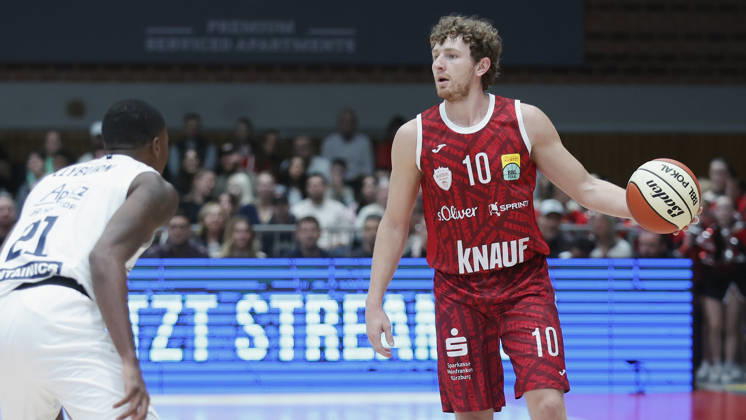 Pictured from left: Kris Clyburn (SYNTAINICS MBC), 21, against Calvin Wishart (Würzburg Baskets), 10, with the ball, August 18, 2026, Fitness First Würzburg Baskets vs. SYNTAINICS MBC, Netto BBL Cup, Round of 16, Germany, 97072, tectake Arena Würzburg, Copyright: HMBxMedia xJulienxBecker