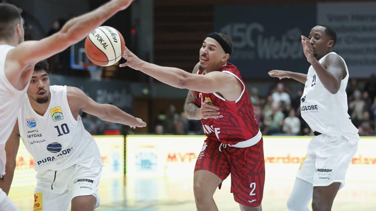 In the photo, from left: Kostja Mushidi (Syntainics MBC, 10), Max Jones (Würzburg Baskets, 2) loses the ball, and Kris Clyburn (Syntainics MBC, 21 18 10 2026), Fitness First Würzburg Baskets vs. SYNTAINICS MBC, Netto BBL Cup, Round of 16, Germany, 97072, tectake Arena Würzburg, Copyright: HMBxMedia xJulienxBecker