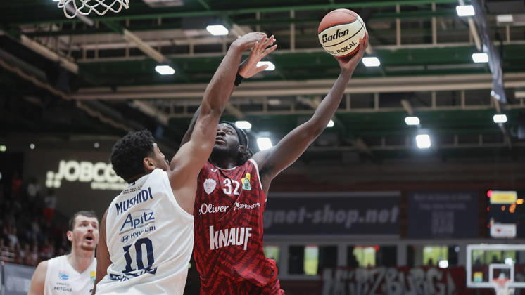 Pictured from left: Kostja Mushidi of Syntainics MBC, No. 10, against Charles Thompson of Wuerzburg Baskets, No. 32, making a layup on 18 October 2026, Fitness First Würzburg Baskets vs. SYNTAINICS MBC, Netto BBL Cup, Round of 16, Germany, 97072, tectake Arena Würzburg, Copyright: HMBxMedia xJulienxBecker