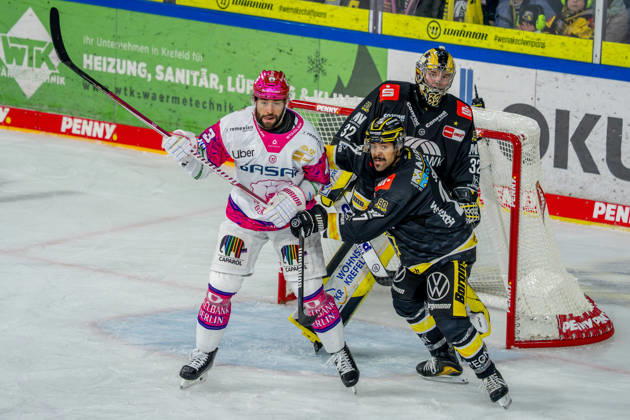 October 18, 2026, xkkux, Ice Hockey, DEL, Krefeld Pinguine vs. Eisbären Berlin, 2026–27 Season, YAYLA Arena, Krefeld; Andreas Eder of the Eisbären Berlin (No. 43) battles C. J. Suess of the Krefeld Pinguine (No. 27) in front of the net defended by goalie Juha Jatkola of the Krefeld Pinguine (No. 32); North Rhine-Westphalia, Germany