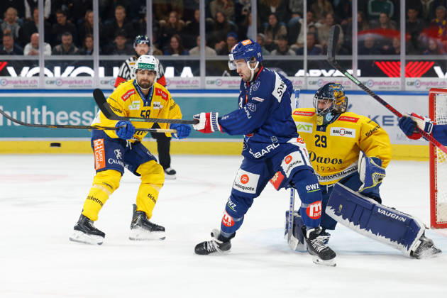 October 20, 2026, Swiss Life Arena, Zurich, SWITZERLAND, 2026–2027 Season, Men s Ice Hockey National League, ZSC Lions vs. HC Davos, Thierry Bader (ZSC) vs. Frederic Allard (HC Davos) in front of goalie Sandro Aeschlimann (HC Davos)