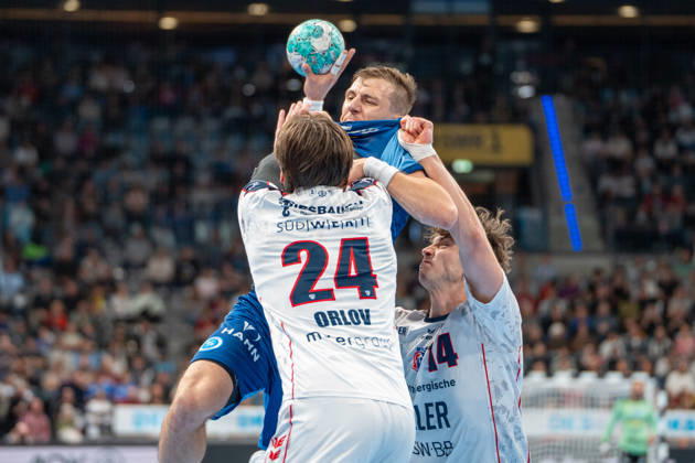 Handball I Men I 2026–2027 Season I Bundesliga I Matchday 10 I TVB Stuttgart vs. SG BBM Bietigheim I October 22, 2026 Simone Mengon 15, TVB Stuttgart with the ball, defended by Maxim Orlov 24, SG BBM Bietigheim, and Fynn Luca Nicolaus 14, SG BBM Bietigheim; Stuttgart Porsche Arena, Baden-Württemberg, Germany Copyright: xLobeca MaxxPetershansx