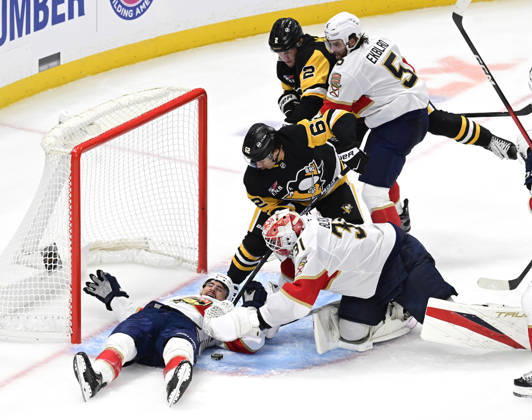 Pittsburgh Penguins left wing Andrei Kuzmenko (62) and Penguins center Hendrix Lapierre reaches for the puck as Florida Panthers right wing Garnet Hathaway (21) protects the goal with his body during the second period at PPG Paints Arena in Pittsburgh on Thursday, October 22, 2026.  PIT2026102208 ARCHIExCARPENTER