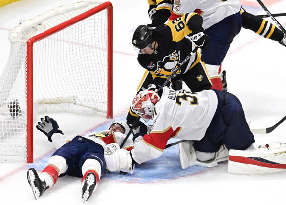 Pittsburgh Penguins left wing Andrei Kuzmenko (62) and Penguins center Hendrix Lapierre reaches for the puck as Florida Panthers right wing Garnet Hathaway (21) protects the goal with his body during the second period at PPG Paints Arena in Pittsburgh on Thursday, October 22, 2026.  PIT2026102210 ARCHIExCARPENTER