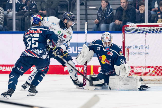 Justin Scott of the Iserlohn Roosters, 20, misses a shot against Fabio Wagner of EHC Red Bull Munich, 55, and Mathias Niederberger, goaltender for EHC Red Bull Munich, 35, GER, EHC Red Bull Munich vs. Iserlohn Roosters, DEL, 2026–2027 season, Matchday 11, October 23, 2026. Photo: HMB Media, Franz Feiner Copyright: HMBxMedia FranzxFeiner