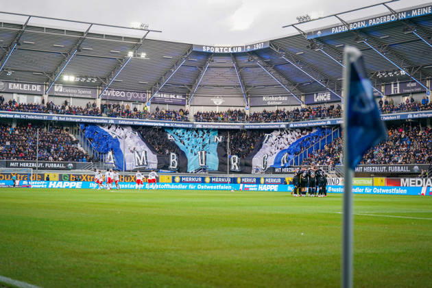 Germany Soccer Bundesliga 2026–2027, Matchday 7: SC Paderborn vs. Hamburger SV at Home Deluxe Arena, Paderborn. Panoramic view of the Home Deluxe Arena in Paderborn; interior shot featuring a large blue, black, and white choreographed display by SC Paderborn 07 home fans in the stands; HAMBURG fan choreography; Ultras, fan scene, spectators, flags, fan section, stadium, sports venue, soccer, Bundesliga, team huddle, Hamburger SV, SC Paderborn, corner flag, playing field, floodlights, stadium roof, advertising, sponsors, advertising banners, Merkur, buXtrade, Bad Driburger, Happe, atmosphere Copyright: xJOERANxSTEINSIEKx