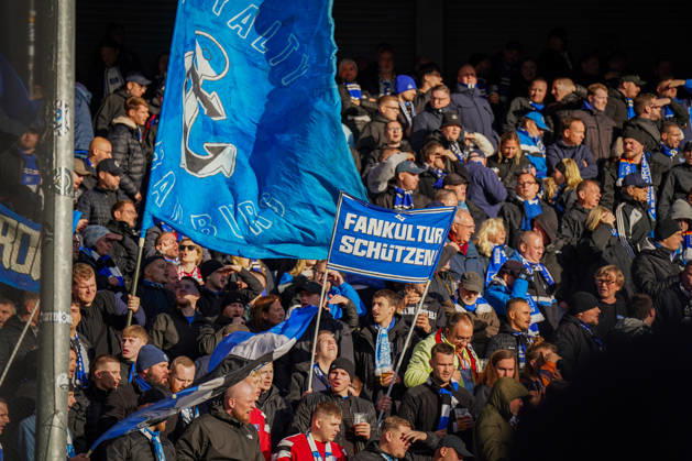 Germany Soccer Bundesliga 2026–2027, Matchday 7: SC Paderborn vs. Hamburger SV at Home Deluxe Arena in Paderborn. Away fans of Hamburger SV (HSV) in the visitors’ section at Home Deluxe Arena in Paderborn. Large blue-and-black HSV flags featuring an anchor and the word Hamburg, as well as a banner. Protecting fan culture: fans, ultras, the fan scene, fan culture, fan protest, spectators, flags, banners, stands, fan section, atmosphere, support, away game, soccer, Bundesliga, SC Paderborn 07, Hamburger SV, stadium, sports venue, fan rights, protect fan culture, wide shot Copyright: xJOERANxSTEINSIEKx