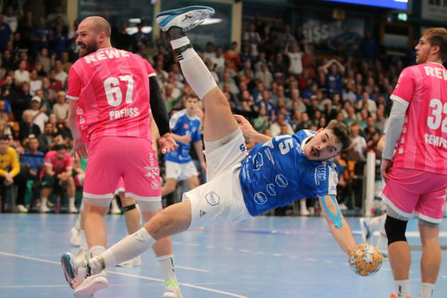 October 24, 2026 Men s Handball 2026–2027, 2nd Division, Matchday 9: Dessau Roßlauer HV 06 vs. SC DHfK Leipzig at Anhalt Arena, Dessau. Referee: Marcel Nowak, Dessau, 15, blue, flies through the air after a rough foul by Moritz Preuss; Leipzig, 67, pink, flies uncontrollably through the air; Dessau Roßlau, Saxony-Anhalt, Germany