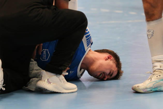 October 24, 2026 Men s Handball 2026–2027, 2nd Division, Matchday 9: Dessau Roßlauer HV 06 vs. SC DHfK Leipzig at Anhalt Arena, Dessau. Marcel Nowak, Dessau, 15, in blue, is lying on the ground after a rough foul and is receiving medical attention Dessau Roßlau Saxony-Anhalt Germany
