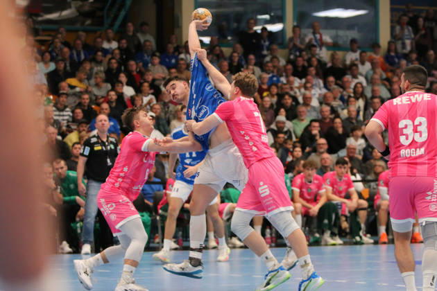 October 24, 2026 Men s Handball 2026–2027, 2nd Division, Matchday 9: Dessau Roßlauer HV 06 vs. SC DHfK Leipzig at Anhalt Arena, Dessau. Referee: Marcel Nowak (Dessau), 15, in blue, is stopped from taking a shot on goal by former Dessau players Fritz Leon Haake (Leipzig, 6, in pink) and Tim Hertzfeld (Leipzig, 72, in pink) Dessau Roßlau Saxony-Anhalt Germany