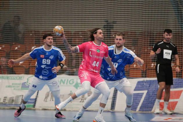 October 24, 2026 Men s Handball 2026–2027, 2nd Division, Matchday 9: Dessau Roßlauer HV 06 vs. SC DHfK Leipzig at Anhalt Arena, Dessau. Dean Bombac (Leipzig), 44, in pink with the ball; Leon Ciudad of Dessau, 20, in blue, screens him; Dessau Roßlau, Saxony-Anhalt, Germany