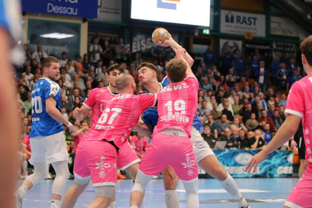 October 24, 2026 Men s Handball 2026–2027, 2nd Division, Matchday 9: Dessau Roßlauer HV 06 vs. SC DHfK Leipzig at Anhalt Arena, Dessau. Marcel Nowak (Dessau, 15, in blue) takes a shot on goal; Moritz Preuss (Leipzig, 67, in pink, and Finn Schroven, Leipzig, 19, in pink, try to block the shot Dessau-Roßlau, Saxony-Anhalt, Germany