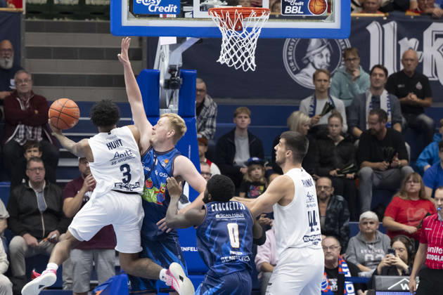 EasyCredit Basketball Bundesliga 2026–2027: Syntainics MBC vs. Rostock Seawolves, Weissenfels, Germany, October 24, 2026. Pictured, from left, in a one-on-one matchup: DeLonnie Hunt (Weissenfels), Bent Leuchten (Rostock) and Jure Planinic (Weissenfels). Weissenfels Stadthalle, Weissenfels, Saxony-Anhalt, Germany