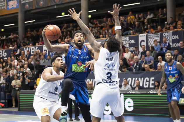 EasyCredit Basketball Bundesliga 2026–2027: Syntainics MBC vs. Rostock Seawolves, Weissenfels, Germany, October 24, 2026. Pictured, from left, in a one-on-one matchup: Kostja Mushidi (Weissenfels), Zach Copeland (Rostock), and DeLonnie Hunt (Weissenfels) at the Weissenfels Stadthalle in Weissenfels, Saxony-Anhalt, Germany