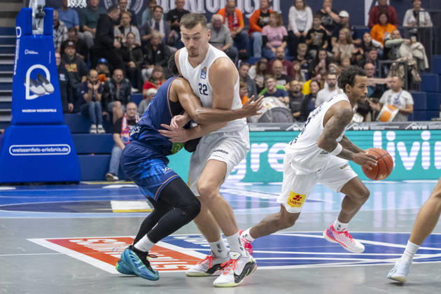 EasyCredit Basketball Bundesliga 2026–2027: Syntainics MBC vs. Rostock Seawolves, Weissenfels, Germany, October 24, 2026. Pictured, from left, in a one-on-one matchup: Zach Copeland (Rostock), Borisa Simanic (Weissenfels) and DeLonnie Hunt (Weissenfels) in a one-on-one battle. Weissenfels Stadthalle, Weissenfels, Saxony-Anhalt, Germany
