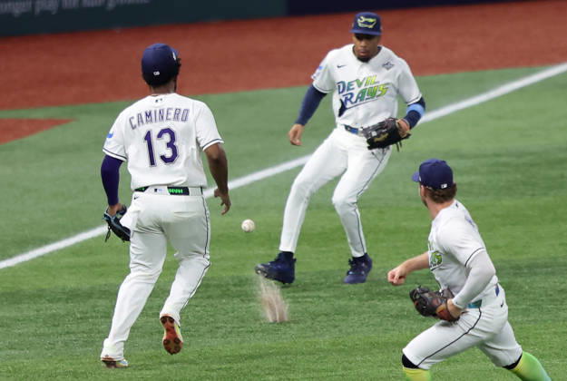 Tampa Bay Rays third baseman Junior Caminero (13) and left fielder Chandler Simpson (14) cannot reach a short fly ball from Milwaukee Brewers designated hitter Christian Yelich which drops for a single in the first inning during game three of the 2026 MLB, Baseball Herren, USA World Series at Tropicana Field in St Petersburg, Florida, on Monday, October 26, 2026.  TPB20261026713 AARONxJOSEFCZYK