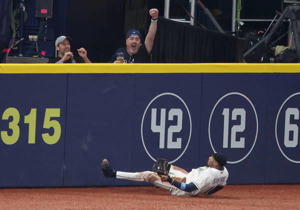 Tampa Bay Rays left fielder Chandler Simpson (14) falls down after slamming against the wall to catch a long fly ball from Milwaukee Brewer Sal Frelick in the second inning during game three of the 2026 MLB, Baseball Herren, USA World Series at Tropicana Field in St Petersburg, Florida, on Monday, October 26, 2026.  TPB20261026729 AARONxJOSEFCZYK