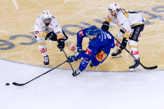 Rico Gredig 8 (EV Zug) vs. Giovanni Morini 23 (HC Lugano) and Aleksi Peltonen 13 (HC Lugano) on October 27, 2026, National League, Regular Season, Ice Hockey, OYM Hall, Zug EV Zug HC Lugano Photo by  Copyright: xJustPictures.ch PhilippxHegglinx